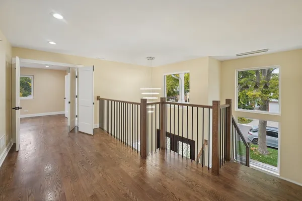 a view of a hallway with wooden floor and windows