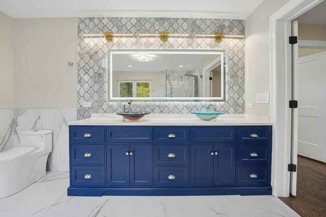 a bathroom with a granite countertop sink vanity and mirror