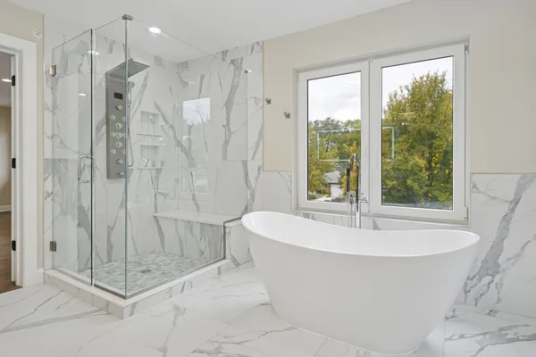 a white bath tub sitting next to a shower