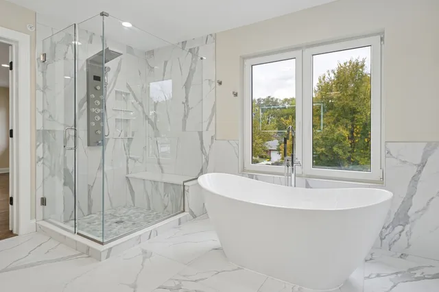 a white bath tub sitting next to a shower