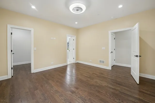 an empty room with wooden floor and entrance