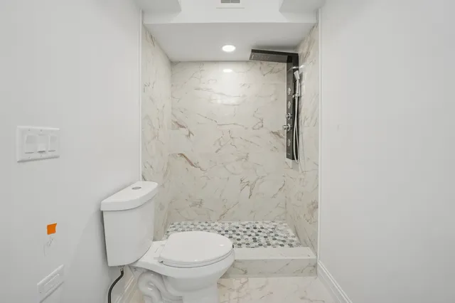 a bathroom with a toilet and a shower