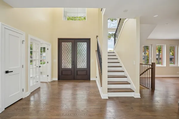 a view of a hallway with wooden floor and stairs