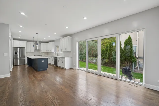 a large kitchen with stainless steel appliances granite countertop a large counter top a large window and a kitchen view