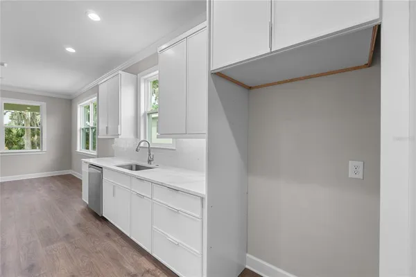 an empty room with windows and ceiling fan