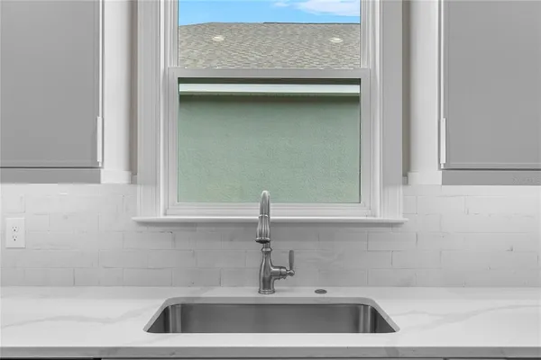 an empty room with a ceiling fan and a window