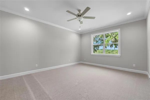 en empty room with windows and ceiling fan