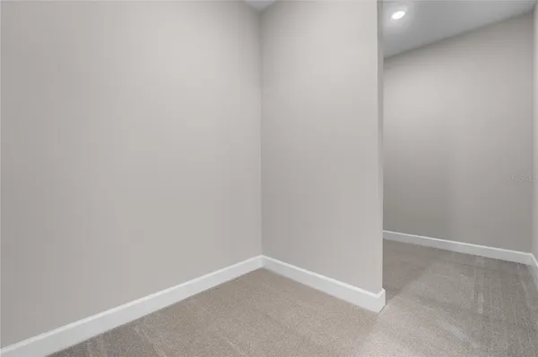 a view of an empty room with a chandelier fan