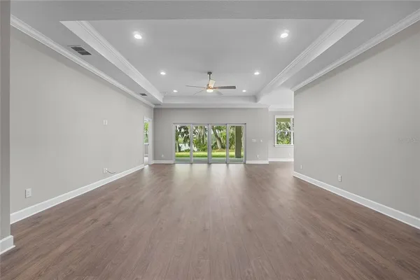 a view of a room with wooden floor fan and window