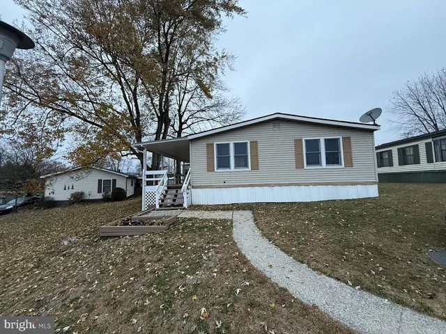 a front view of a house with a tree