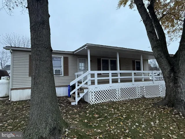 a white house that has a tree in front of it