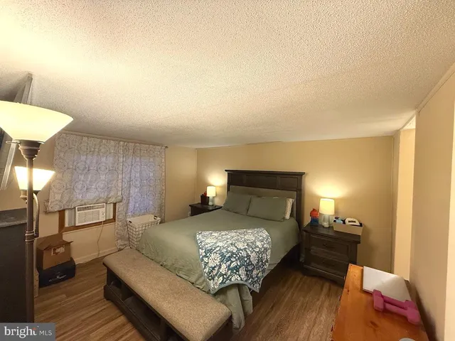 a bedroom with a bed and a lamp with the wooden floor