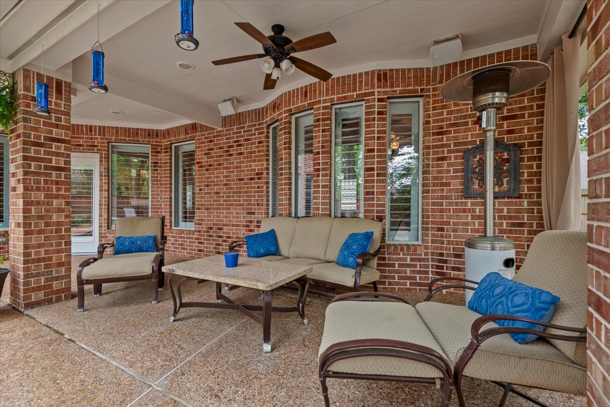 15519 Stallion Point Circle Cypress, TX 77429 - Photo 32 of 37 Spacious covered patio area featuring a ceiling fan, brick walls, and an exposed aggregate concrete floor
