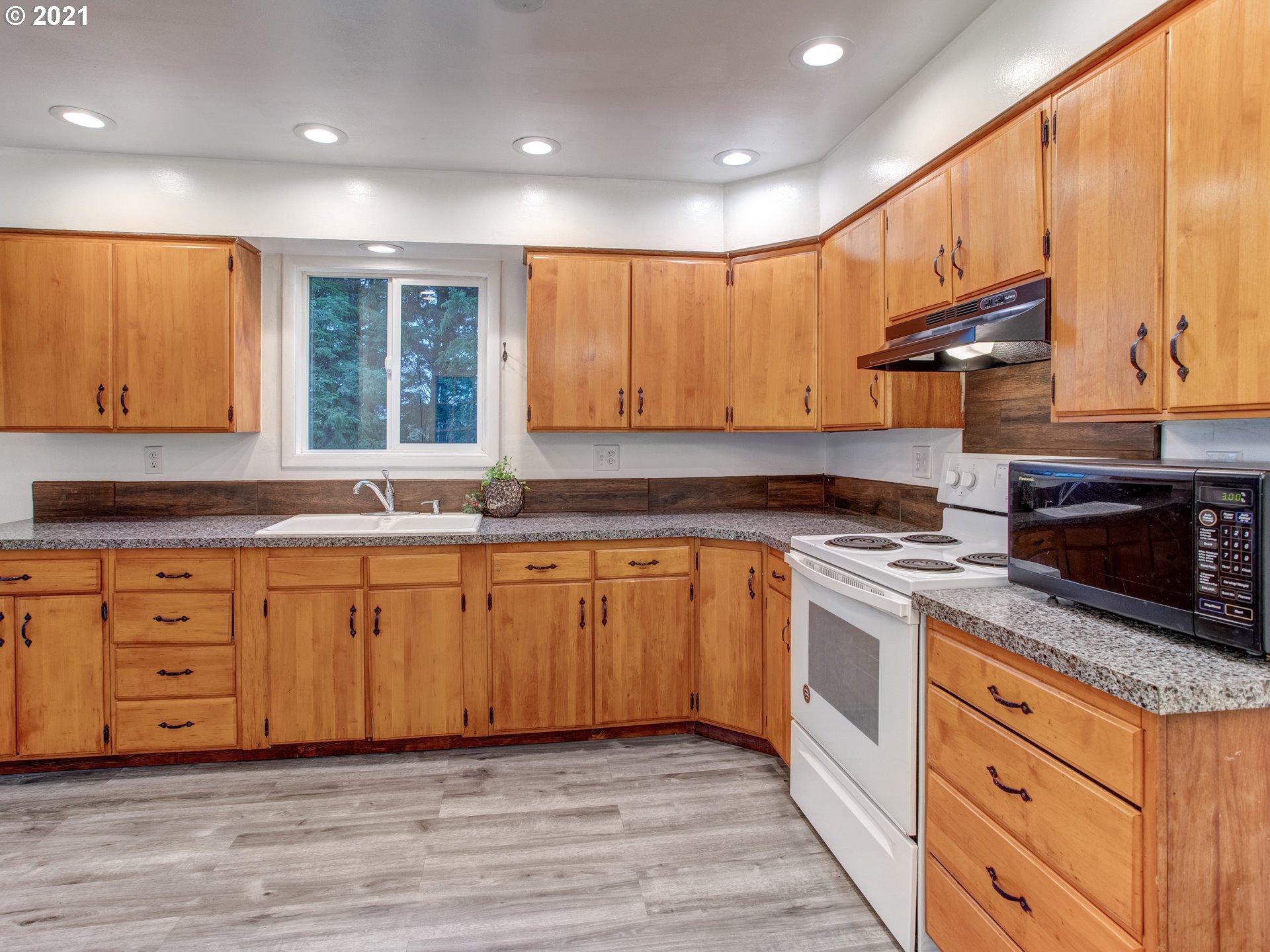 2517 Northeast 199th Street Ridgefield, WA 98642 - Photo 11 of 25 a kitchen with granite countertop wooden cabinets stainless steel appliances and a window
