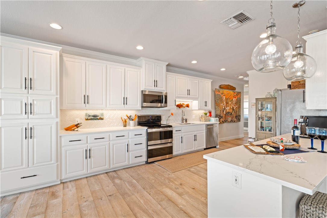 13 Sea Shell Shores Rockport, TX 78382 - Photo 17 of 40 a kitchen with kitchen island granite countertop a sink stainless steel appliances cabinets and a counter top space