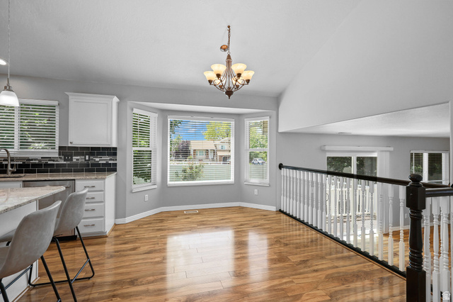 142 East 2675th Street South Clearfield, UT 84015 - Photo 12 of 49 Bright dining area featuring a bay window, wood-finish flooring, and a decorative chandelier