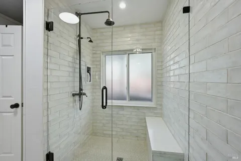 a bathroom with a shower and a glass door