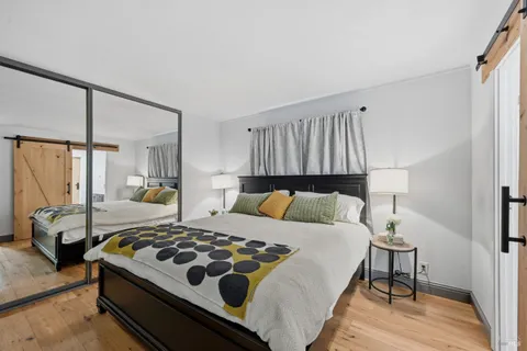 a bedroom with a bed and wooden floor