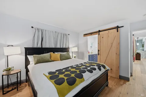 a bedroom with a bed and wooden floor