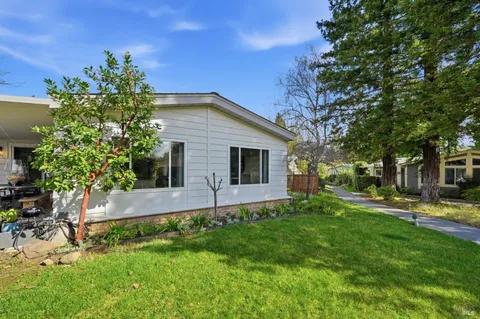 a front view of a house with a yard and trees