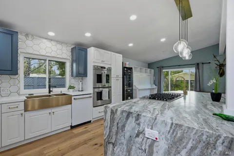 a large kitchen with kitchen island a large counter top space appliances and cabinets