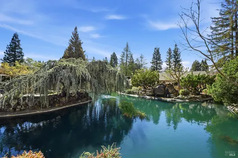 an aerial view of a house with swimming pool patio and lake view