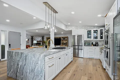 a large kitchen with stainless steel appliances kitchen island granite countertop a large counter top and stainless steel appliances
