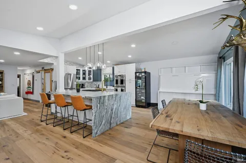 a living room with furniture a wooden floor and a kitchen view