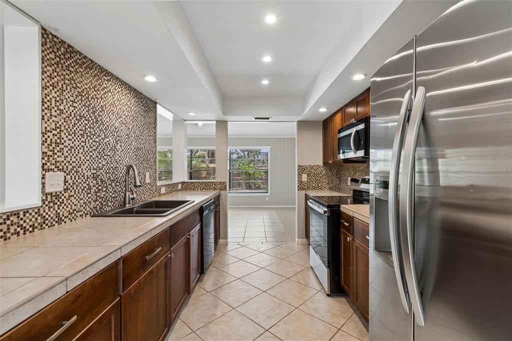 1470 Burnham Lane Dunedin, FL 34698 - Photo 12 of 42 a kitchen with stainless steel appliances granite countertop a sink stove and refrigerator