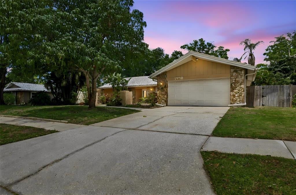1470 Burnham Lane Dunedin, FL 34698 - Photo 3 of 42 a front view of a house with a yard and garage