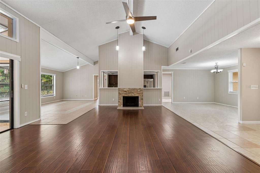 1470 Burnham Lane Dunedin, FL 34698 - Photo 8 of 42 an empty room with wooden floor fireplace and windows