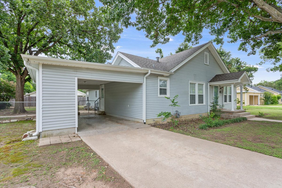 1607 North Harding Avenue Cameron, TX 76520 - Photo 4 of 37 A charming light blue home with a covered driveway offers convenient parking and inviting curb appeal.
