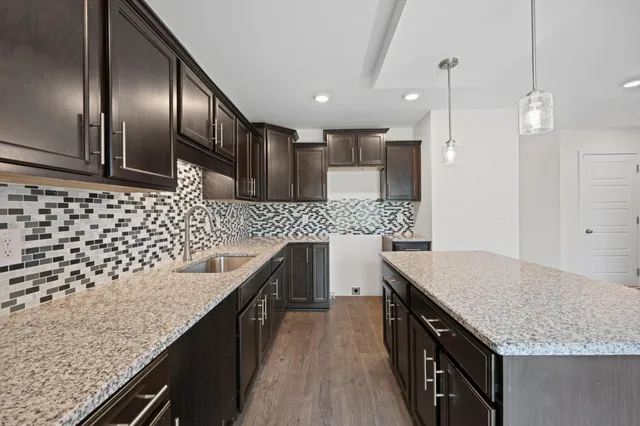 a kitchen with granite countertop stainless steel appliances and wooden cabinets