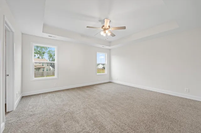 an empty room with windows and fan