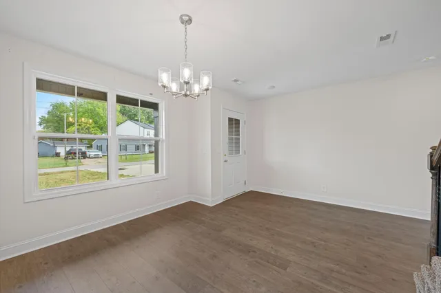 a view of a big room with windows and chandelier