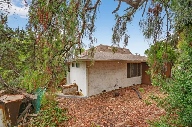 a view of a small house with a yard and sitting area