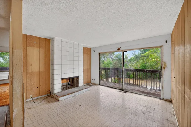 an empty room with fireplace and a window