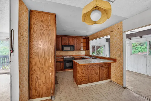 a kitchen with a stove a refrigerator and a microwave