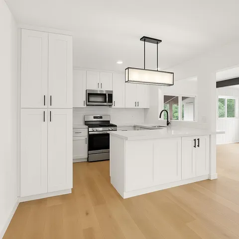 a kitchen with kitchen island granite countertop a stove a sink a refrigerator and white cabinets with wooden floor