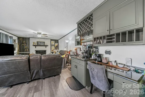 a living room with furniture a flat screen tv and kitchen view
