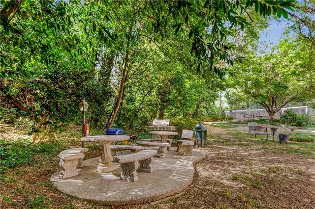 a patio with table and chairs and potted plants