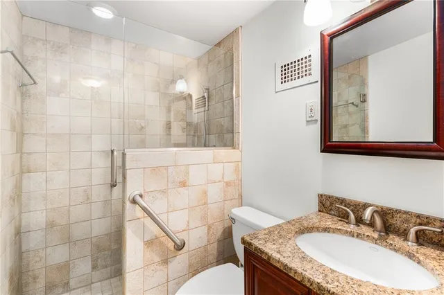 a bathroom with a granite countertop sink a mirror and a shower