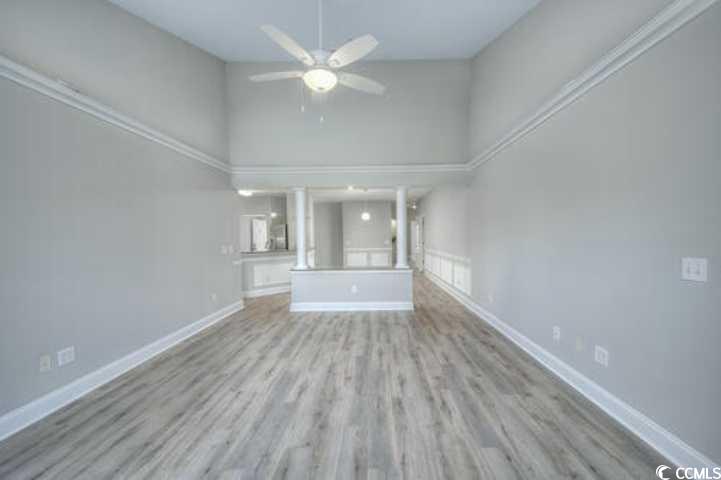 70 Addison Cottage Way, Unit 319 Murrells Inlet, SC 29576 - Photo 11 of 30 Unfurnished living room with a high ceiling, wood finished floors, and a ceiling fan