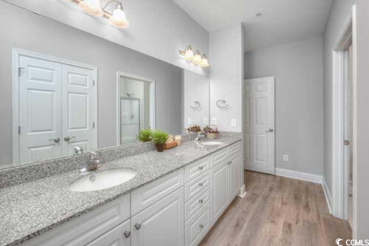 70 Addison Cottage Way, Unit 319 Murrells Inlet, SC 29576 - Photo 19 of 30 Bathroom with double vanity, light wood-style flooring, and an enclosed shower