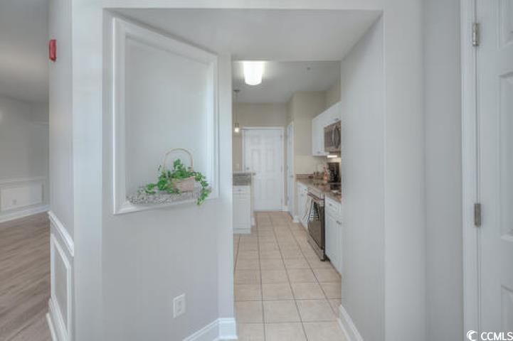 70 Addison Cottage Way, Unit 319 Murrells Inlet, SC 29576 - Photo 2 of 30 Kitchen featuring white cabinetry, appliances with stainless steel finishes, light countertops, and a decorative wall