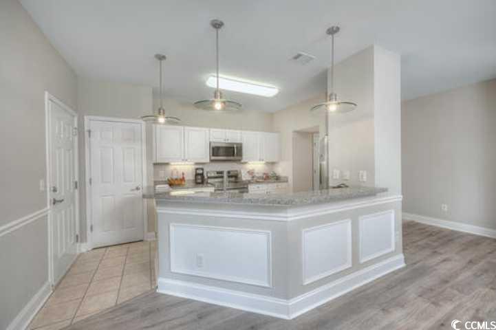 70 Addison Cottage Way, Unit 319 Murrells Inlet, SC 29576 - Photo 6 of 30 Kitchen with white cabinetry, decorative light fixtures, stainless steel microwave, and a peninsula