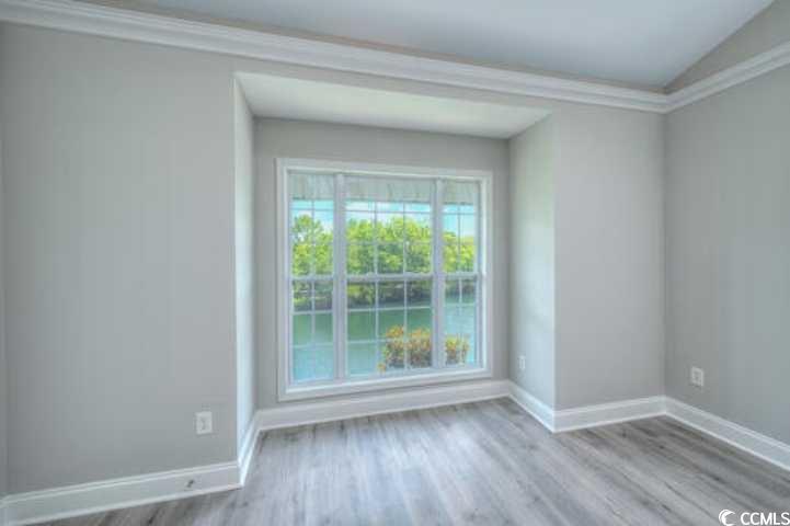 70 Addison Cottage Way, Unit 319 Murrells Inlet, SC 29576 - Photo 10 of 30 Spare room featuring ornamental molding, light wood-type flooring, and a water view
