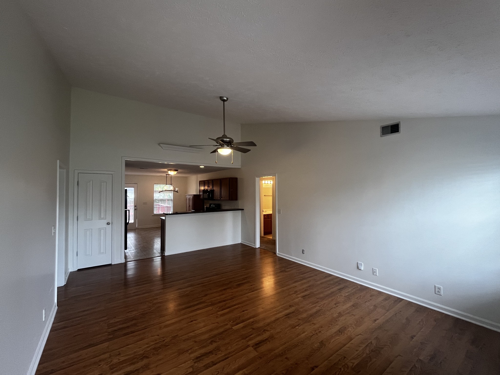 1175 Catawba Way Murfreesboro, TN 37130 - Photo 2 of 11 a view of an empty room and kitchen view with wooden floor