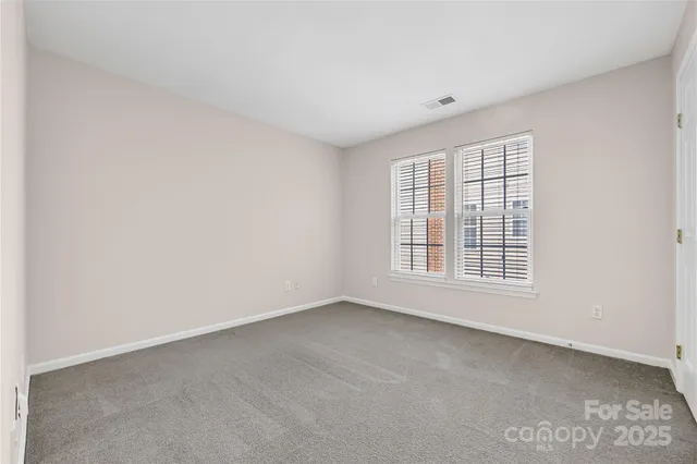 an empty room with closet and windows
