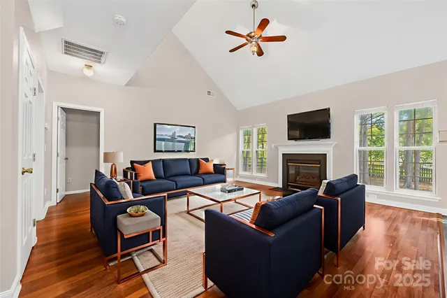 a living room with furniture a fireplace and a flat screen tv